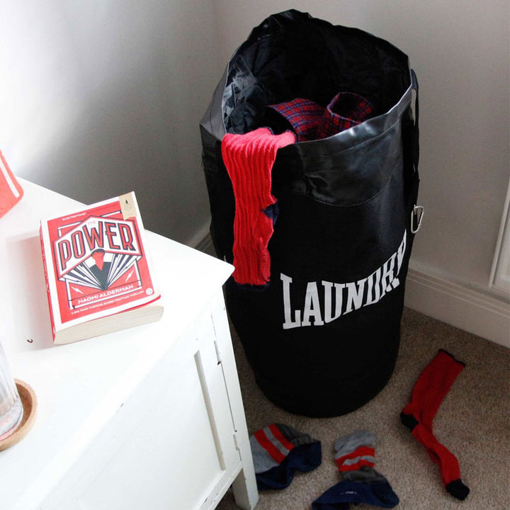 שק כביסה תלוי בחדר שינה עמוס בבגדים